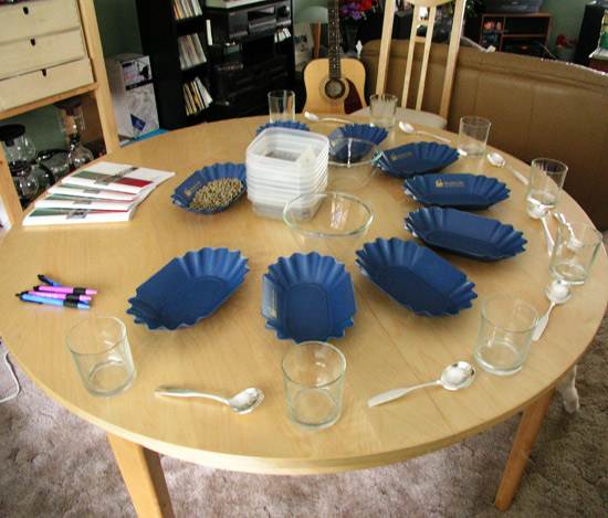 Setting up a coffee cupping session, cups, spoons and trays.